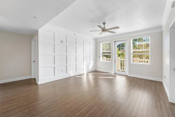 an empty room with wooden floor and windows