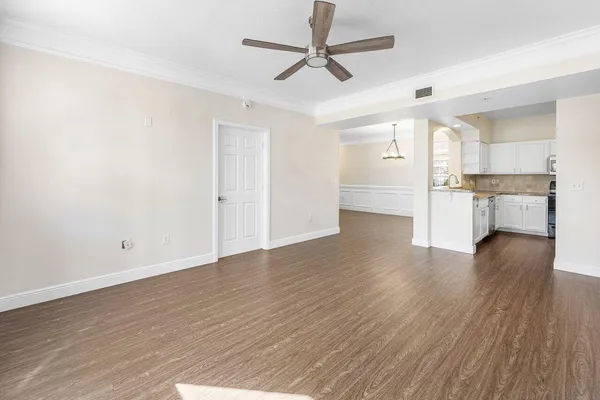 a view of a livingroom with wooden floor and a ceiling fan