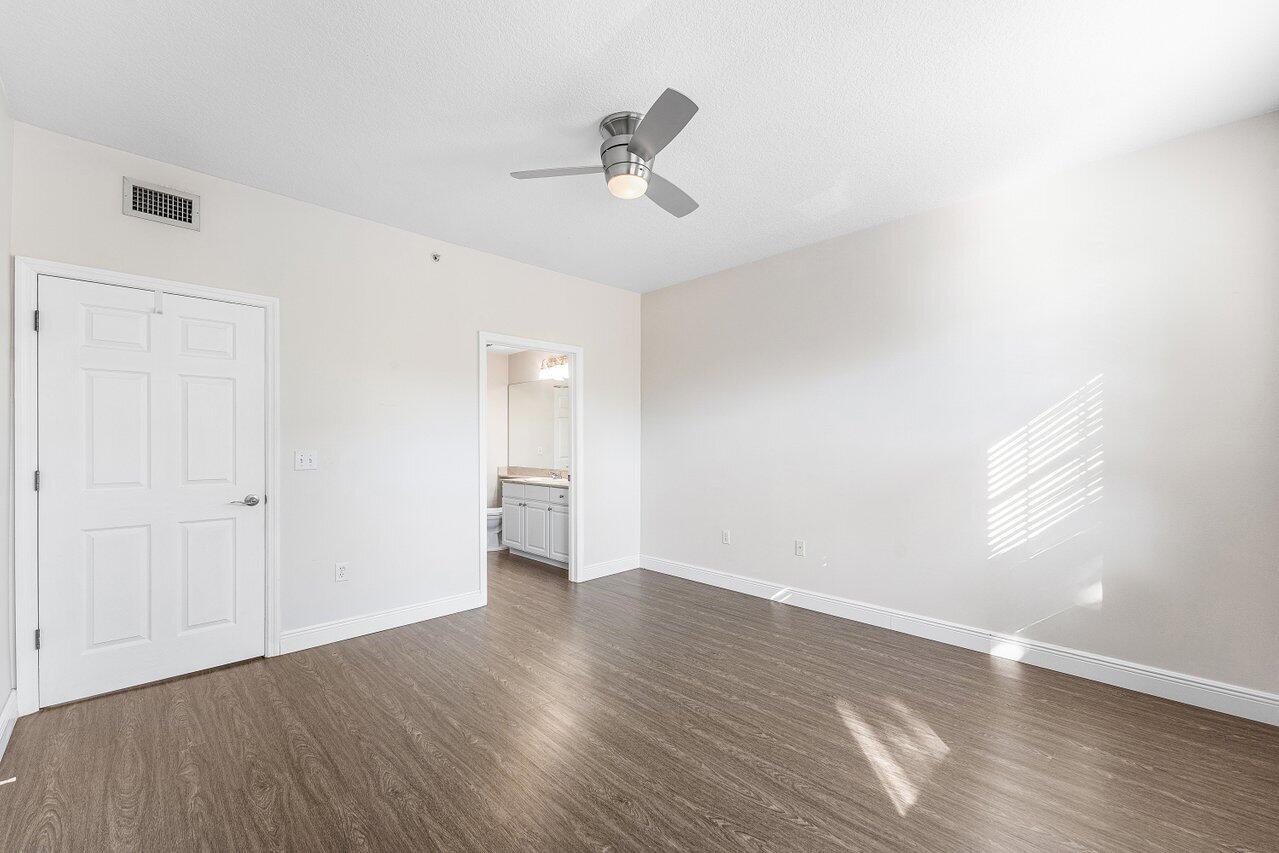 276 Murcia Drive, Unit 301 Jupiter, FL 33458 - Photo 24 of 52 a view of empty room with wooden floor and ceiling fan