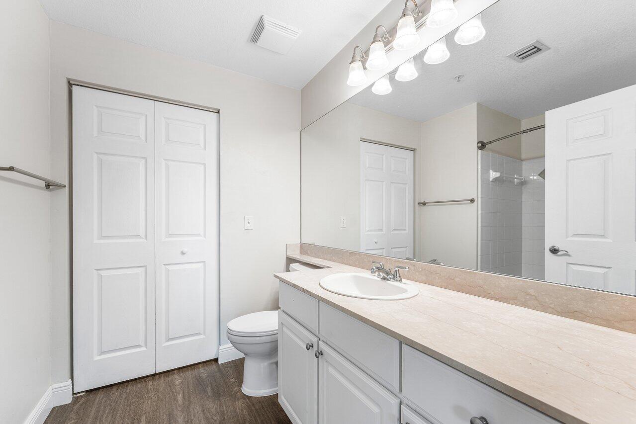 276 Murcia Drive, Unit 301 Jupiter, FL 33458 - Photo 25 of 52 a bathroom with a sink a toilet and a large mirror