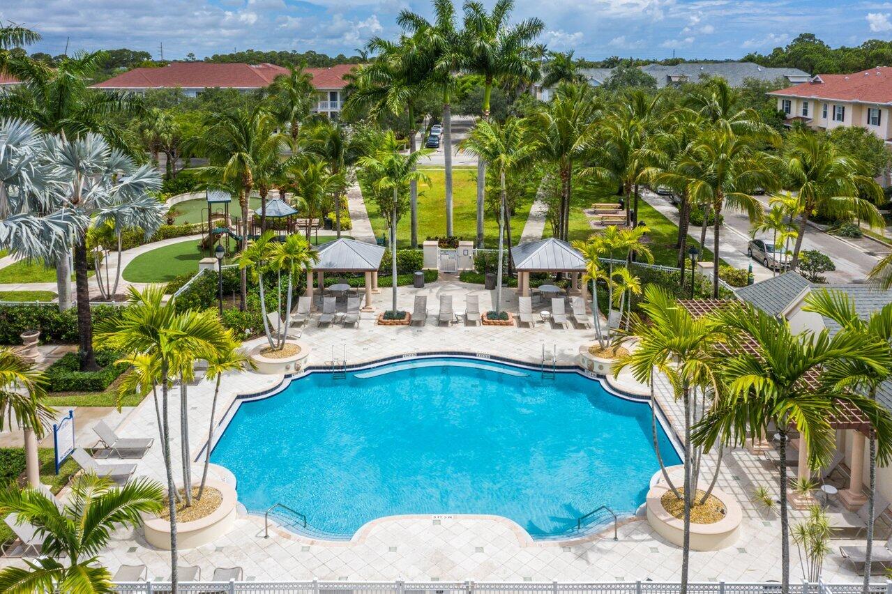 276 Murcia Drive, Unit 301 Jupiter, FL 33458 - Photo 51 of 52 a view of swimming pool with a table and chairs under an umbrella