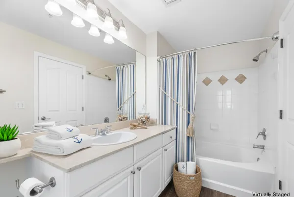 a bathroom with a sink vanity tub and shower