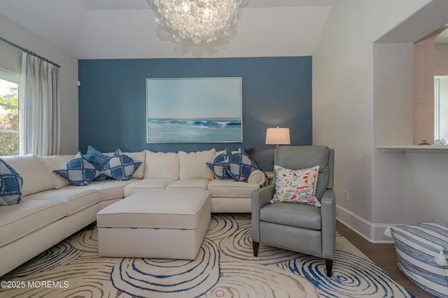 a living room with furniture a flat screen tv and floor to ceiling window