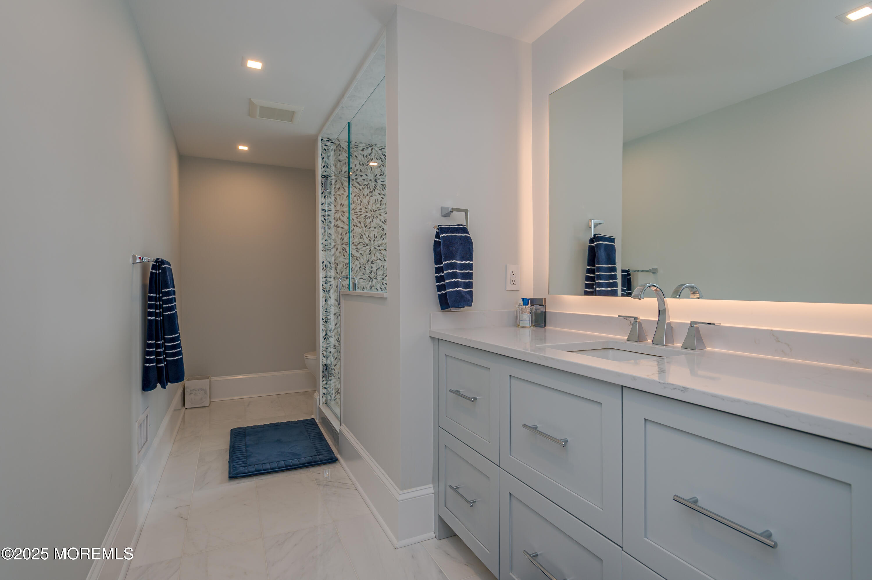 112 Passaic Avenue Spring Lake, NJ 07762 - Photo 26 of 69 a spacious bathroom with a shower sink and mirror