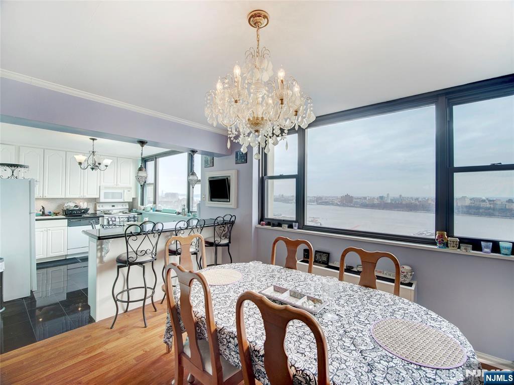 250 Gorge Road, Unit 28A Cliffside Park, NJ 07010 - Photo 16 of 37 a view of a dining room with furniture a chandelier and wooden floor
