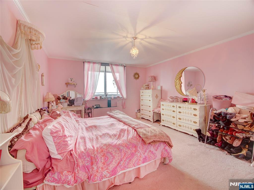 250 Gorge Road, Unit 28A Cliffside Park, NJ 07010 - Photo 19 of 37 a bed room with a bed mirror and a chandelier