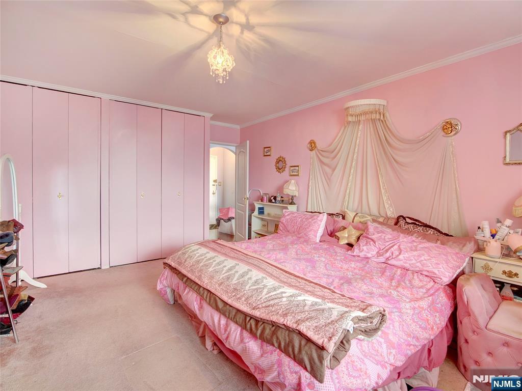 250 Gorge Road, Unit 28A Cliffside Park, NJ 07010 - Photo 21 of 37 a bedroom with a bed and a chandelier