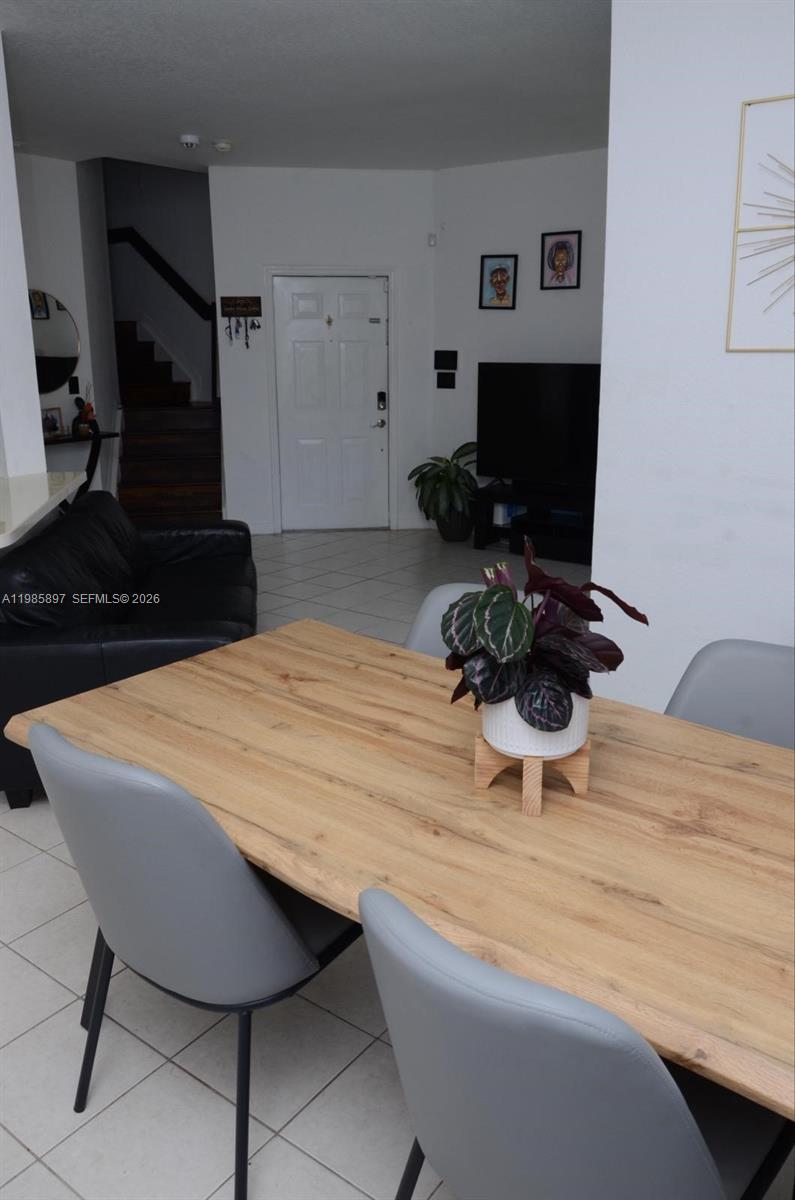 12505 Southwest 124th Court Miami, FL 33186 - Photo 3 of 29 a room with a chandelier a flat screen tv and a table