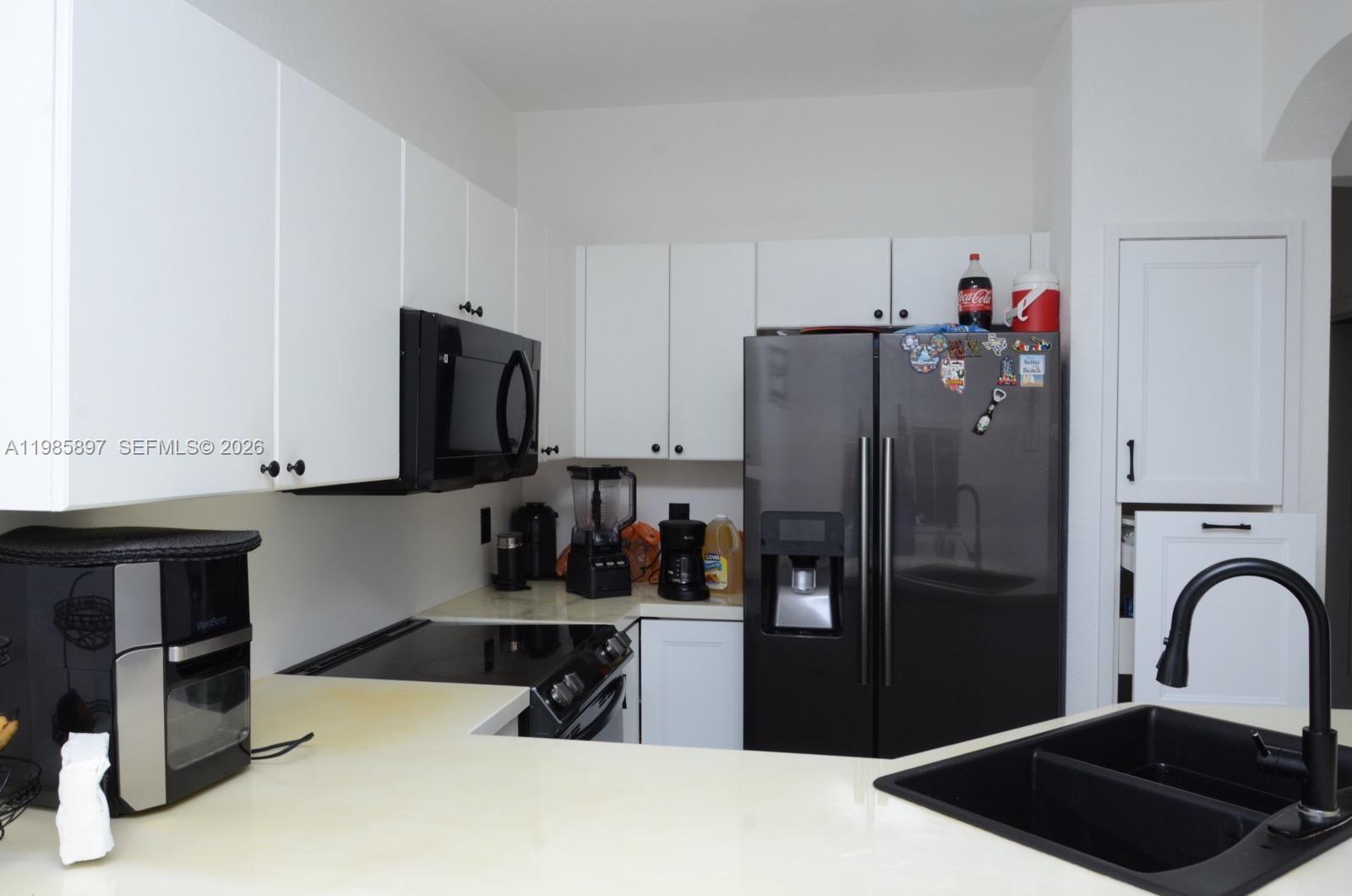 12505 Southwest 124th Court Miami, FL 33186 - Photo 5 of 29 a kitchen with a refrigerator and a stove top oven