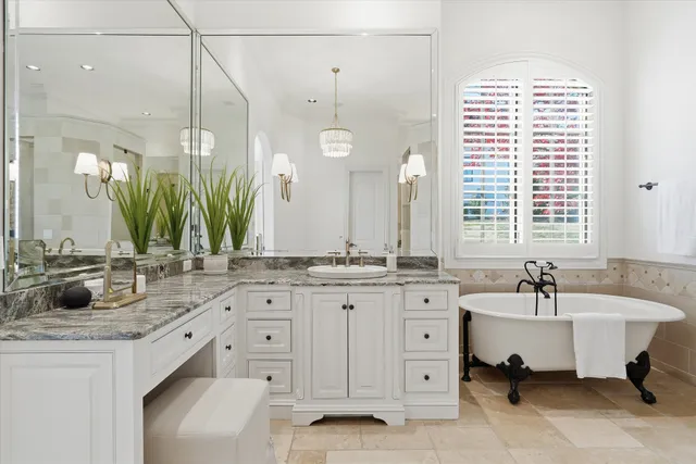 a kitchen with stainless steel appliances granite countertop a stove a sink dishwasher and white cabinets with wooden floor