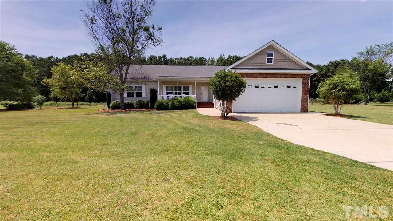 1920 Sanders Road Willow Spring, NC 27592 - Photo 2 of 29 a front view of a house with a yard and garage