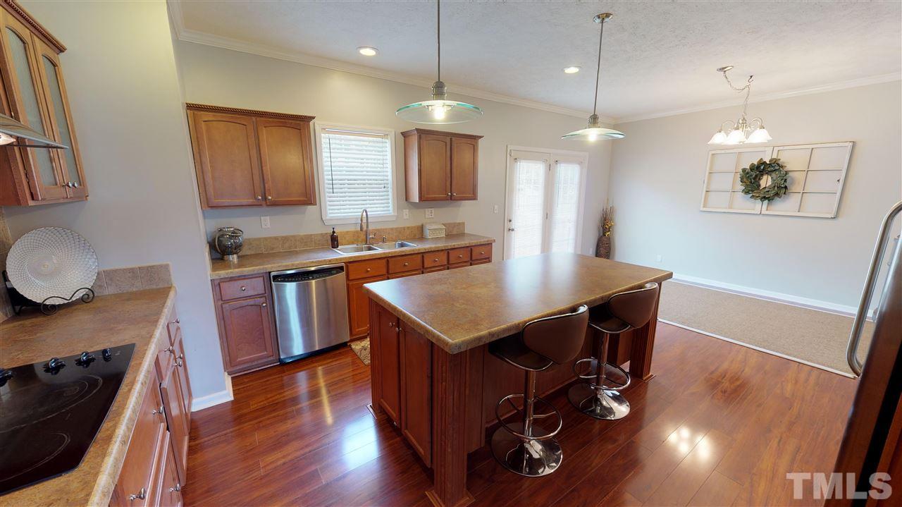 1920 Sanders Road Willow Spring, NC 27592 - Photo 11 of 29 a kitchen with a table chairs sink and wooden floor