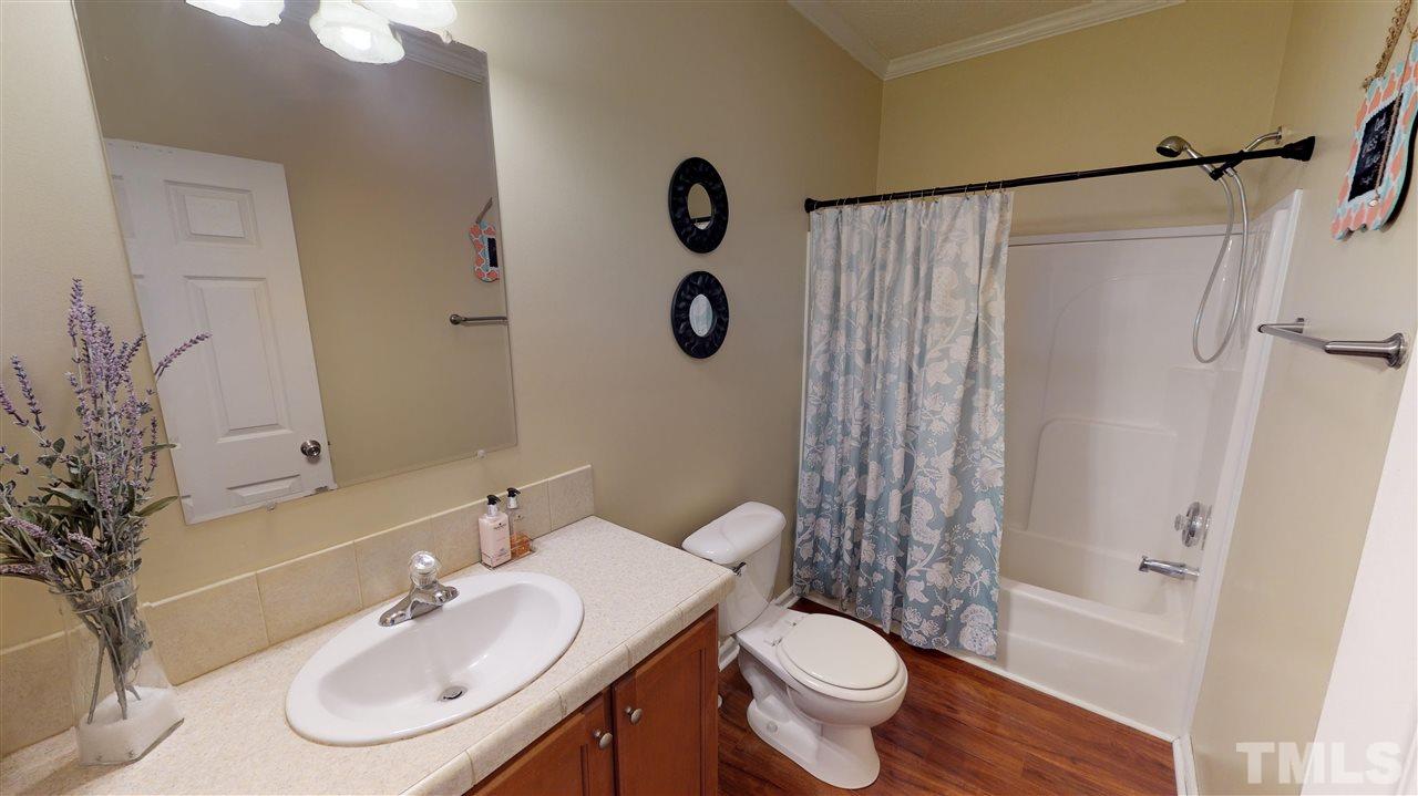 1920 Sanders Road Willow Spring, NC 27592 - Photo 18 of 29 a bathroom with a sink toilet and shower