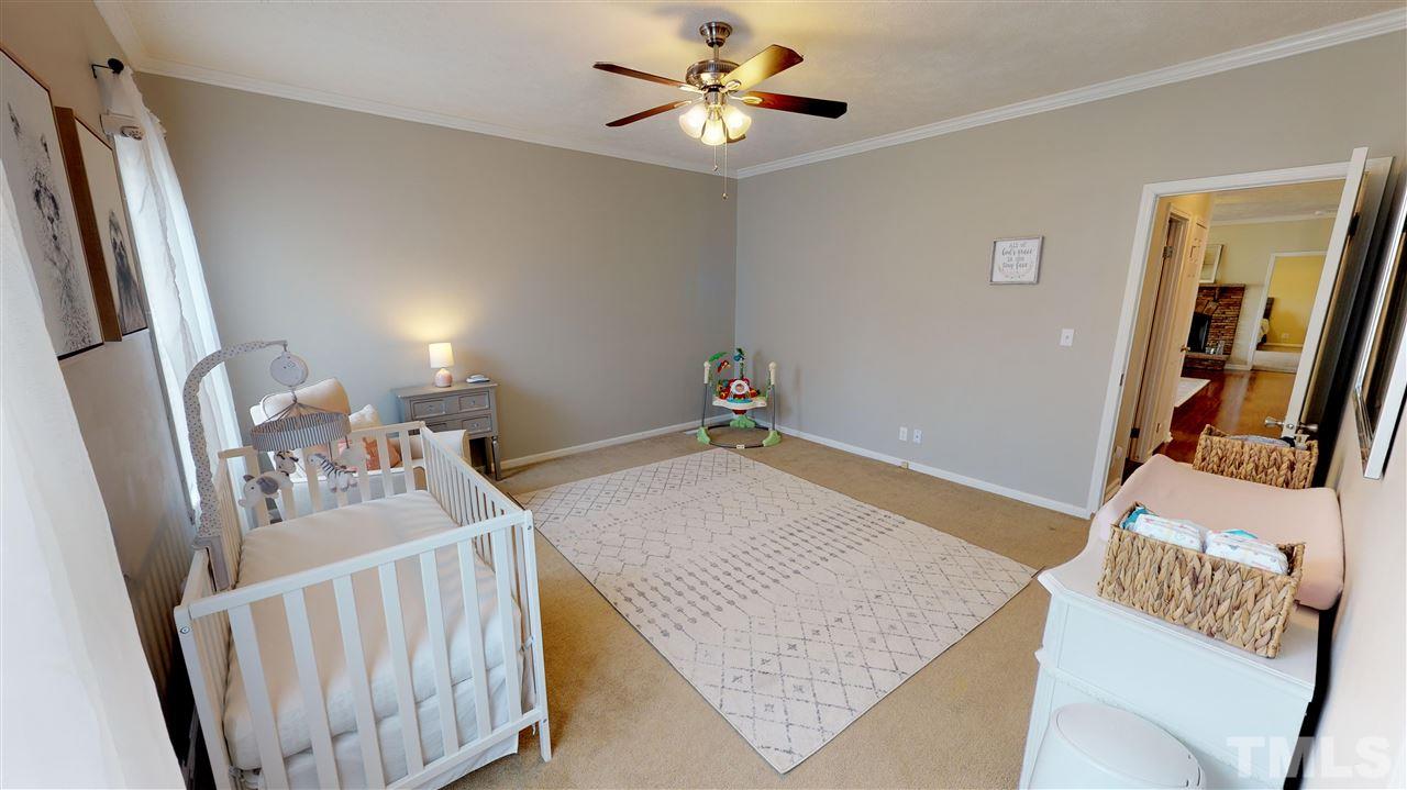 1920 Sanders Road Willow Spring, NC 27592 - Photo 21 of 29 a bedroom with furniture and a chandelier
