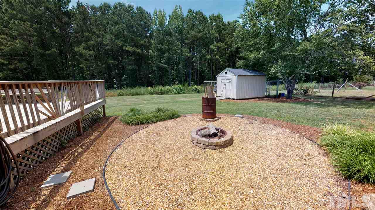 1920 Sanders Road Willow Spring, NC 27592 - Photo 27 of 29 a view of a house with backyard and trees