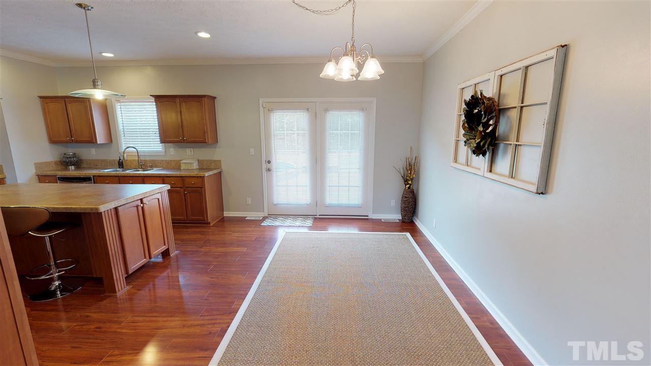 1920 Sanders Road Willow Spring, NC 27592 - Photo 8 of 29 a view of a hallway with wooden floor and chandelier