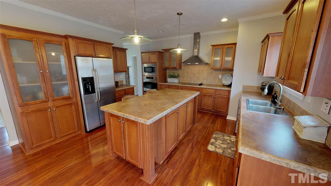 1920 Sanders Road Willow Spring, NC 27592 - Photo 10 of 29 a kitchen with stainless steel appliances granite countertop a refrigerator a sink a stove and wooden floors