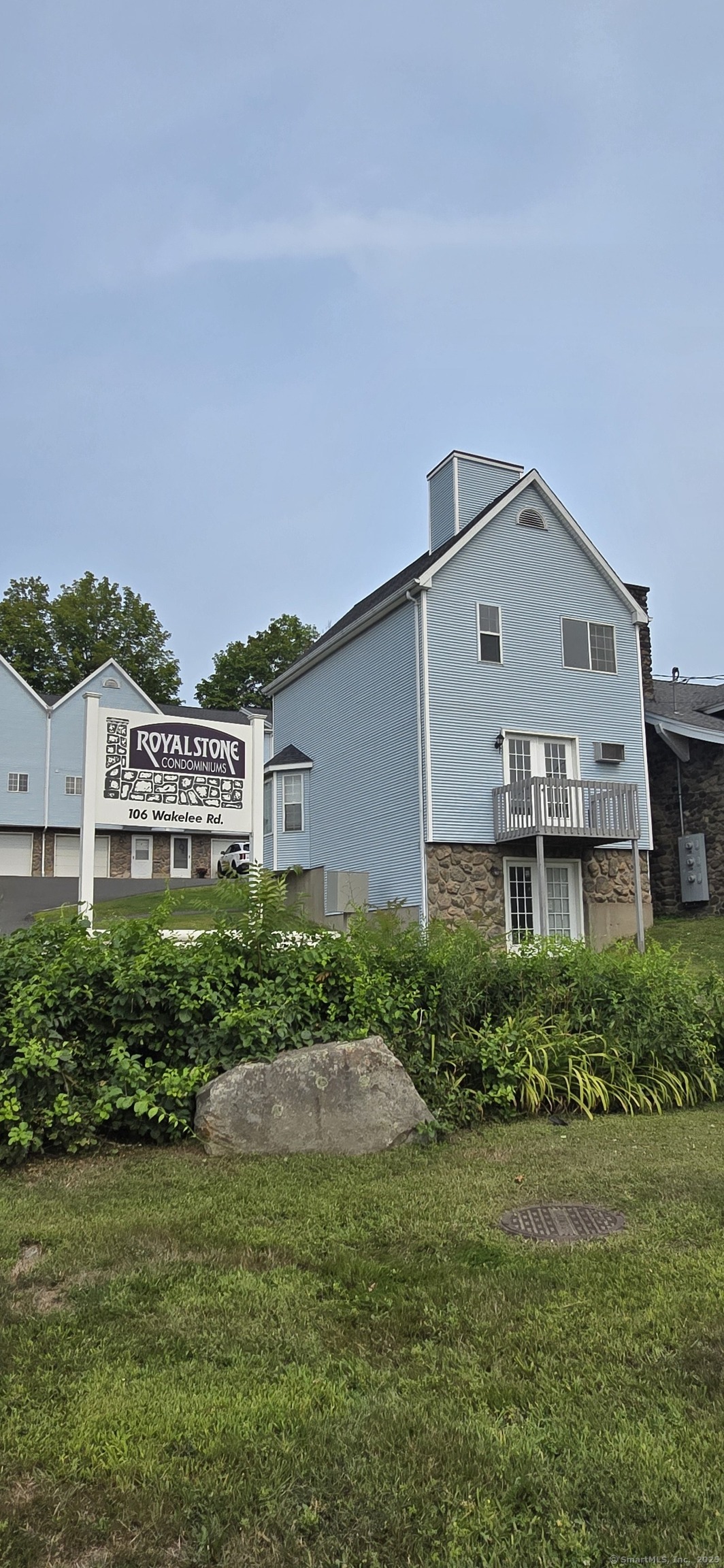 a view of a big house with a big yard plants and large trees