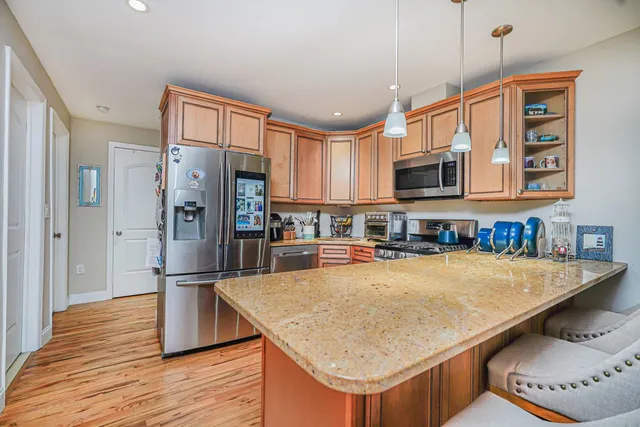 a kitchen with stainless steel appliances granite countertop a sink refrigerator and microwave