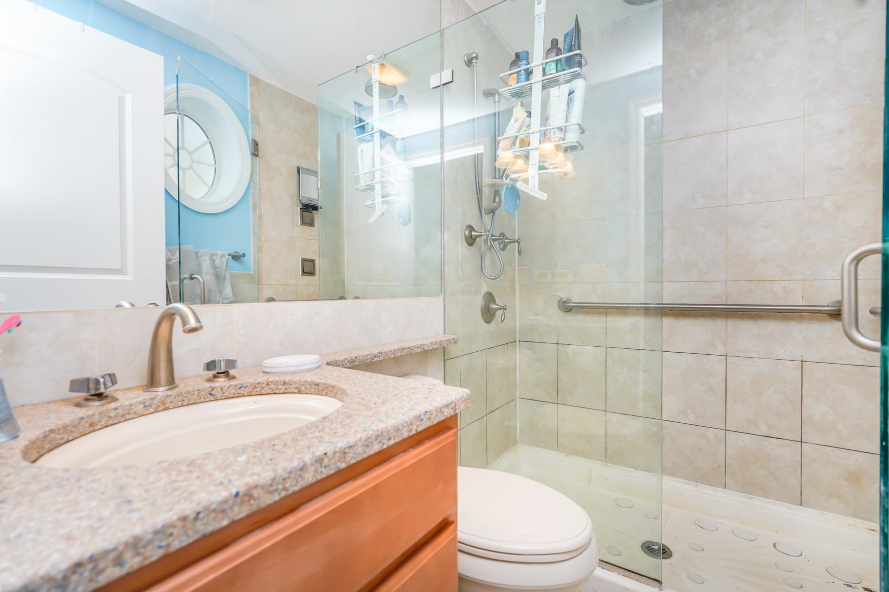 175 Beach 100th Street, Unit 8A Queens, NY 11694 - Photo 17 of 24 a bathroom with a granite countertop sink toilet a mirror and shower