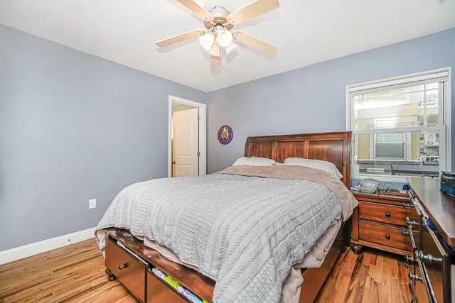 a bedroom with bed and wooden floor