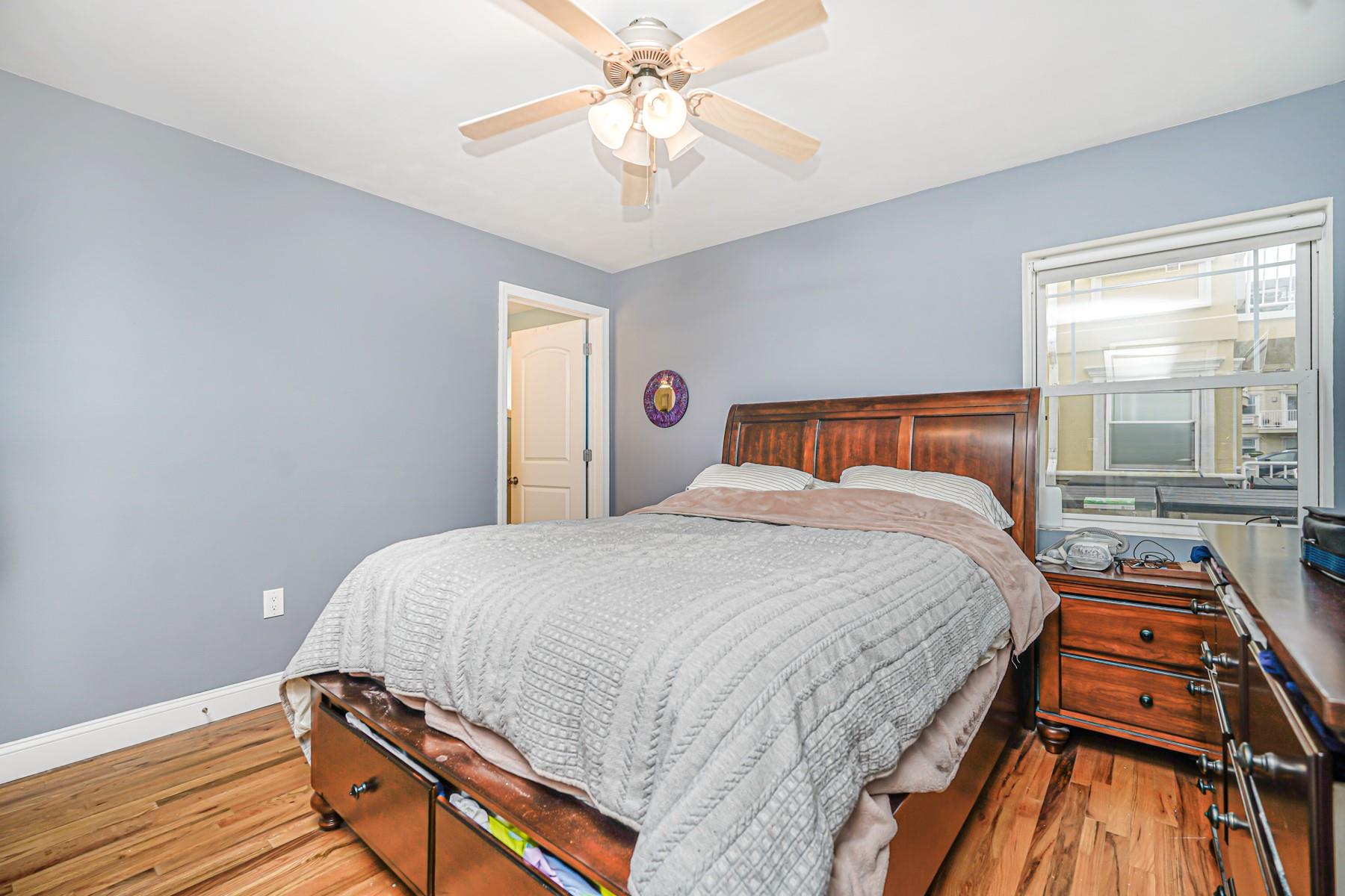 175 Beach 100th Street, Unit 8A Queens, NY 11694 - Photo 18 of 24 a bedroom with bed and wooden floor