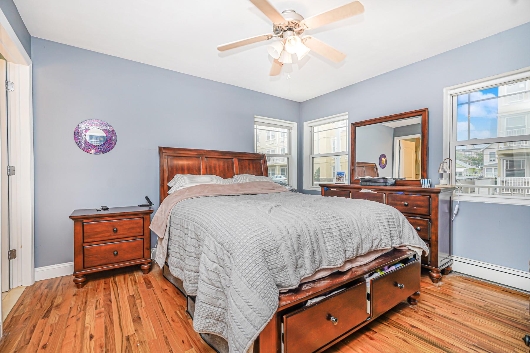 175 Beach 100th Street, Unit 8A Queens, NY 11694 - Photo 19 of 24 a bed room with a bed and a chandelier
