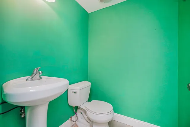 a bathroom with a toilet sink and mirror