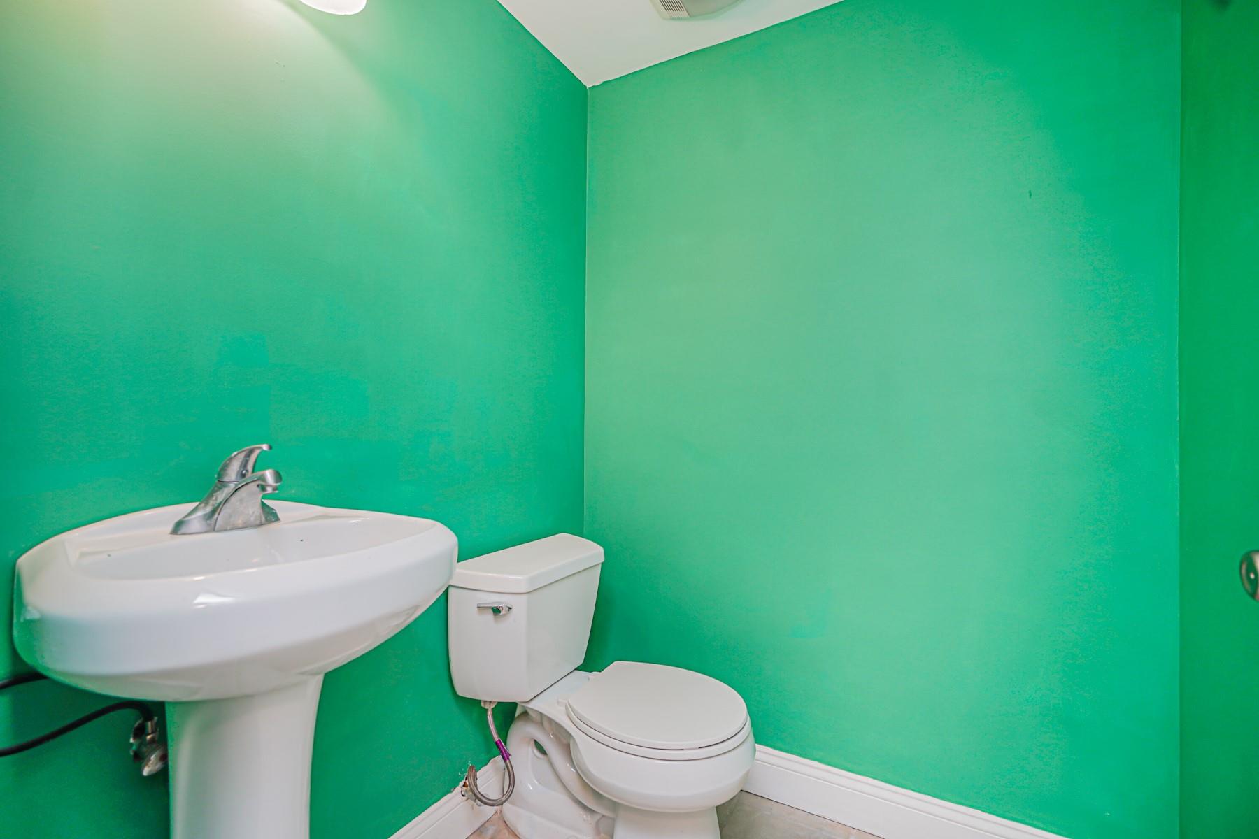 175 Beach 100th Street, Unit 8A Queens, NY 11694 - Photo 22 of 24 a bathroom with a toilet sink and mirror