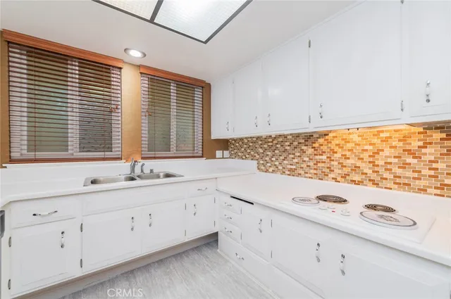 a kitchen with granite countertop white cabinets and white appliances