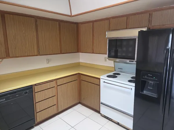 a kitchen with a refrigerator sink and cabinets