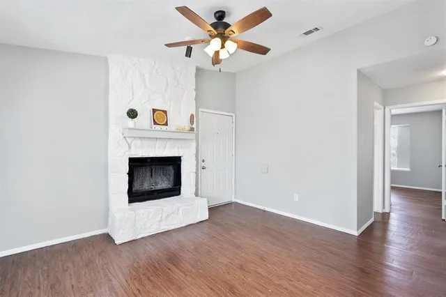 a view of a livingroom with a fireplace and a ceiling fan