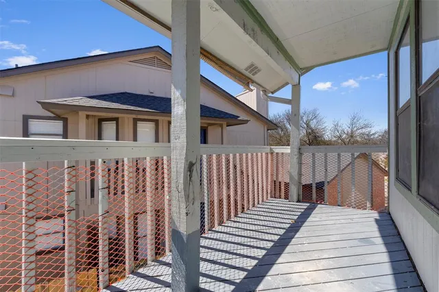 a view of a balcony with wooden floor and fence