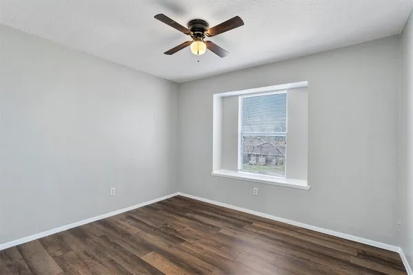 an empty room with fan and windows