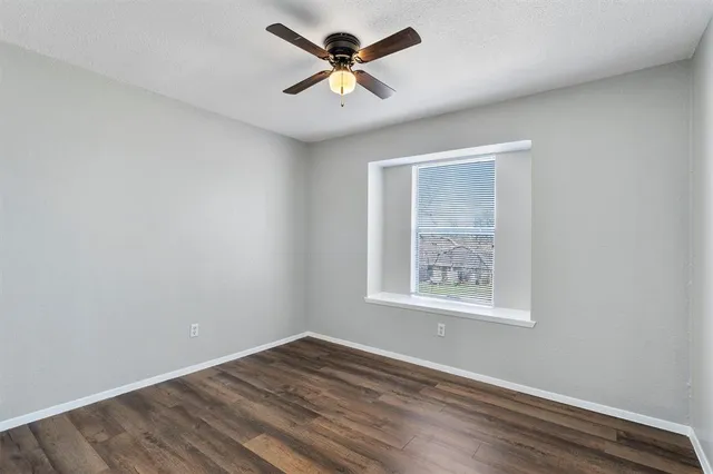 an empty room with fan and windows