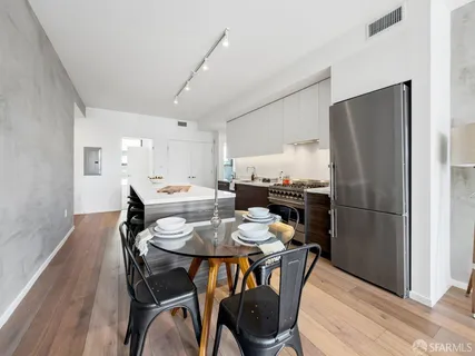 a kitchen with a dining table chairs and refrigerator