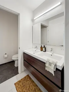 a spacious bathroom with a double vanity sink toilet and a mirror