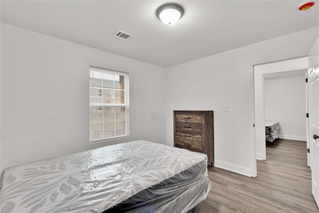 612 Elberta Street Fort Valley, GA 31030 - Photo 11 of 31 a bedroom with a bed and wooden floor