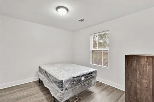 a room with a bed and wooden floor