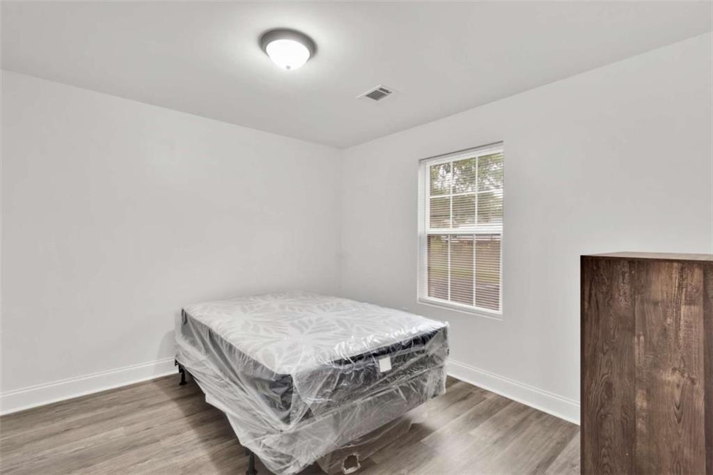 612 Elberta Street Fort Valley, GA 31030 - Photo 14 of 31 a room with a bed and wooden floor