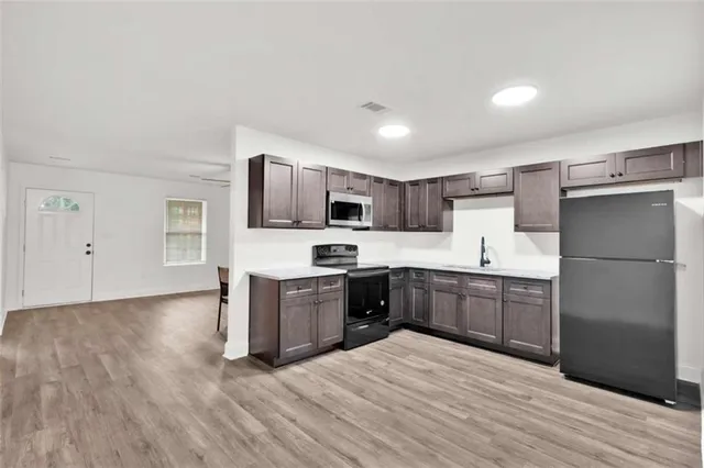 a large kitchen with a refrigerator stove microwave and sink