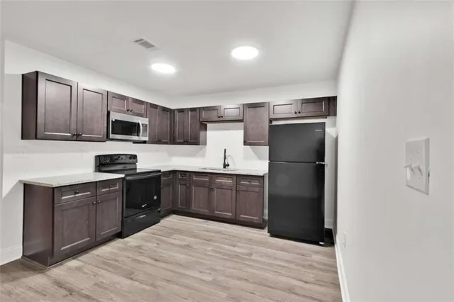 a kitchen with a refrigerator stove microwave and sink