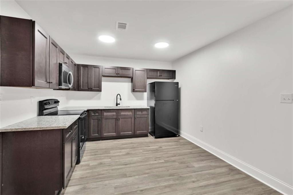 612 Elberta Street Fort Valley, GA 31030 - Photo 20 of 31 a kitchen with stainless steel appliances granite countertop a refrigerator a stove top oven a sink and dishwasher