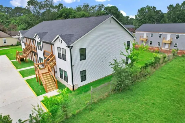 a aerial view of a house next to a big yard and large trees