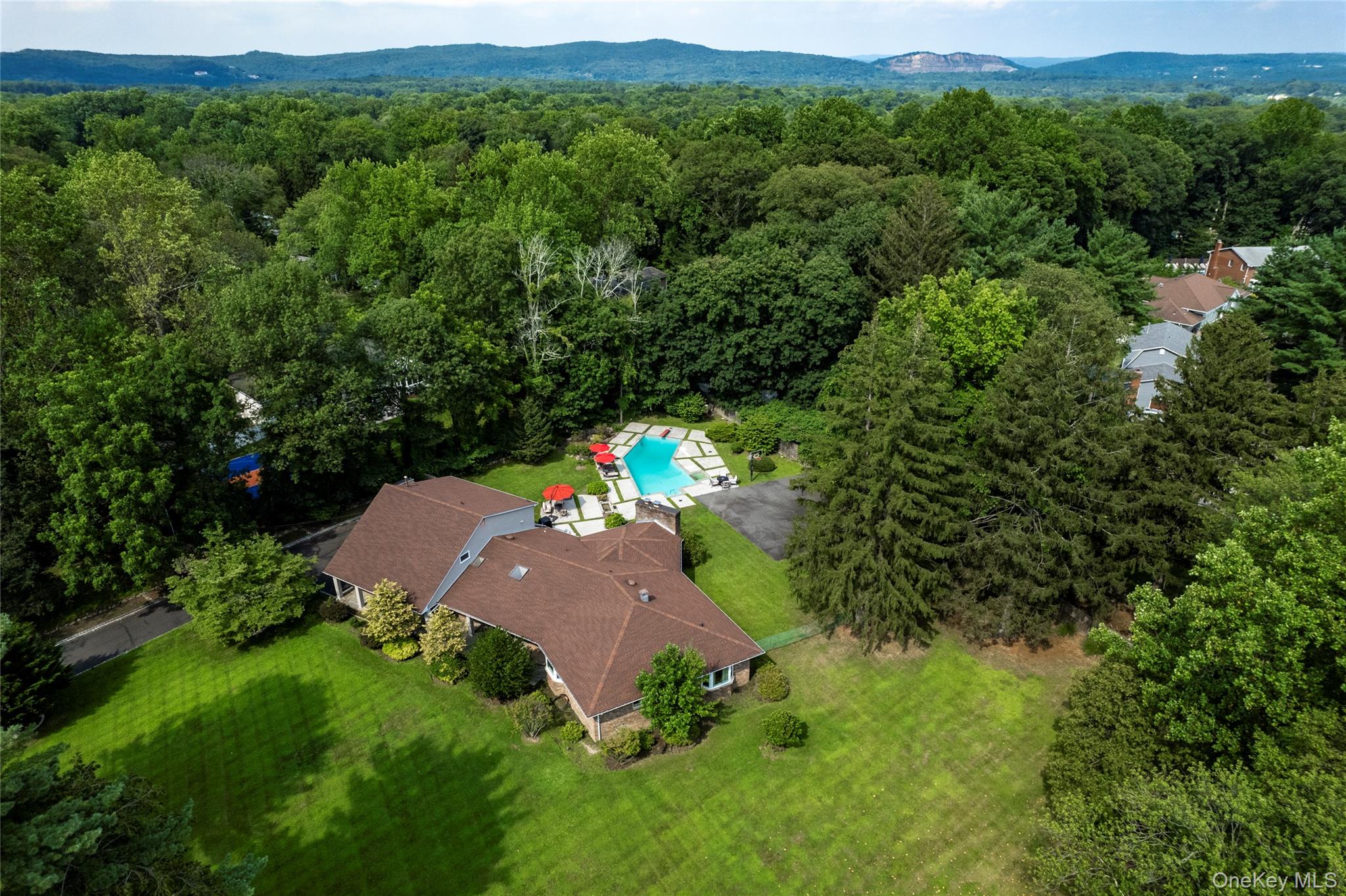 Bird's eye view of a lawn, patio and a inground pool