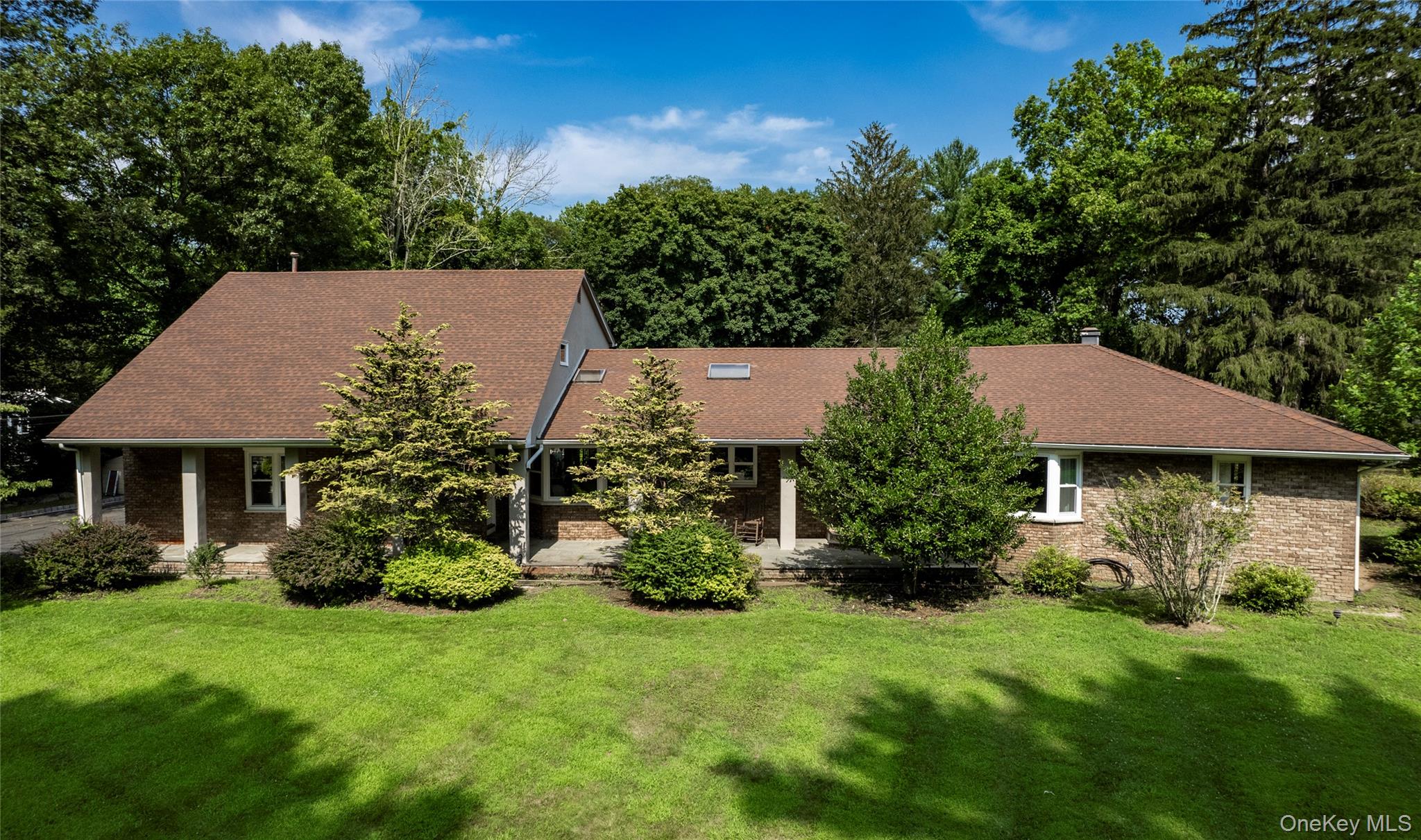 369 Phillips Hill Road New City, NY 10956 - Photo 2 of 40 View of front of home featuring a front lawn, a shingled roof, and brick siding