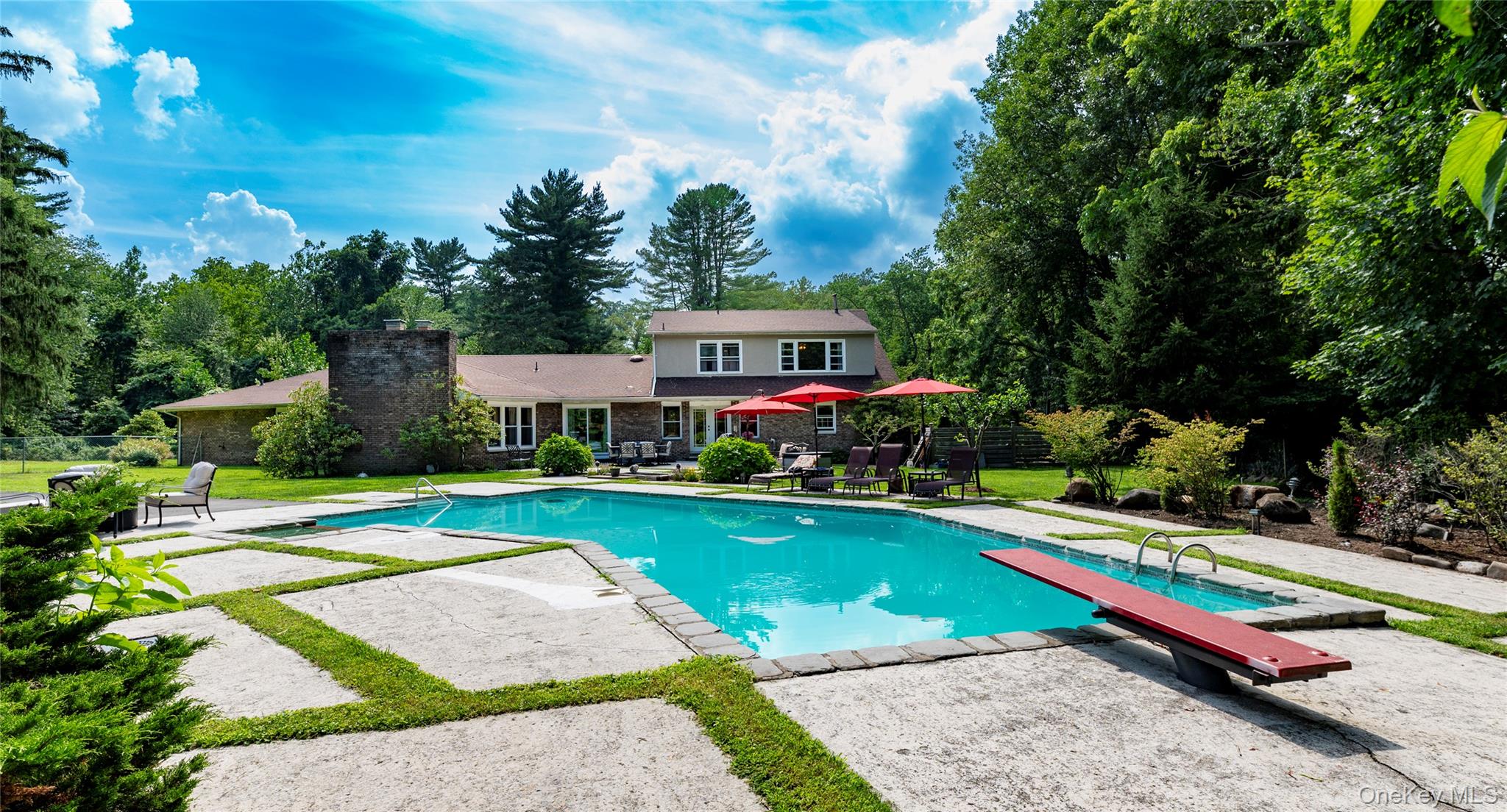 369 Phillips Hill Road New City, NY 10956 - Photo 36 of 40 Outdoor pool with a patio area, a diving board, and view of wooded area