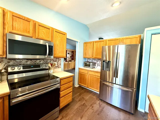 a kitchen with stainless steel appliances a stove refrigerator and microwave