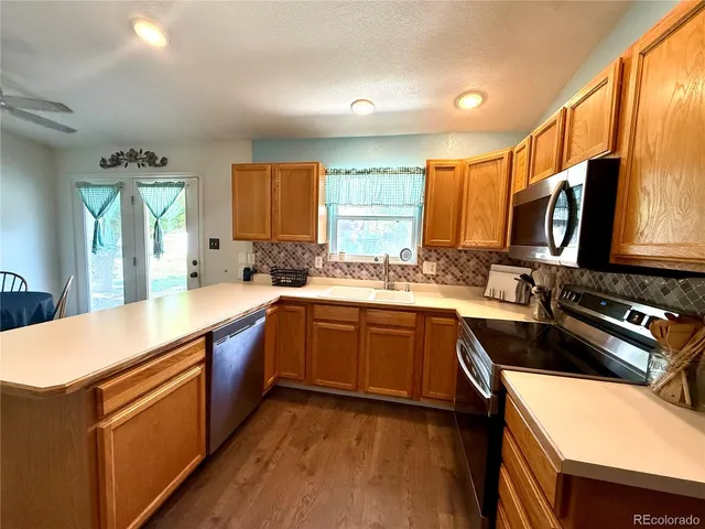 a kitchen with stainless steel appliances granite countertop a sink and a stove