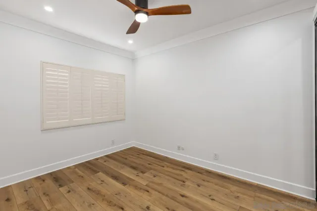 an empty room with a window and ceiling fan